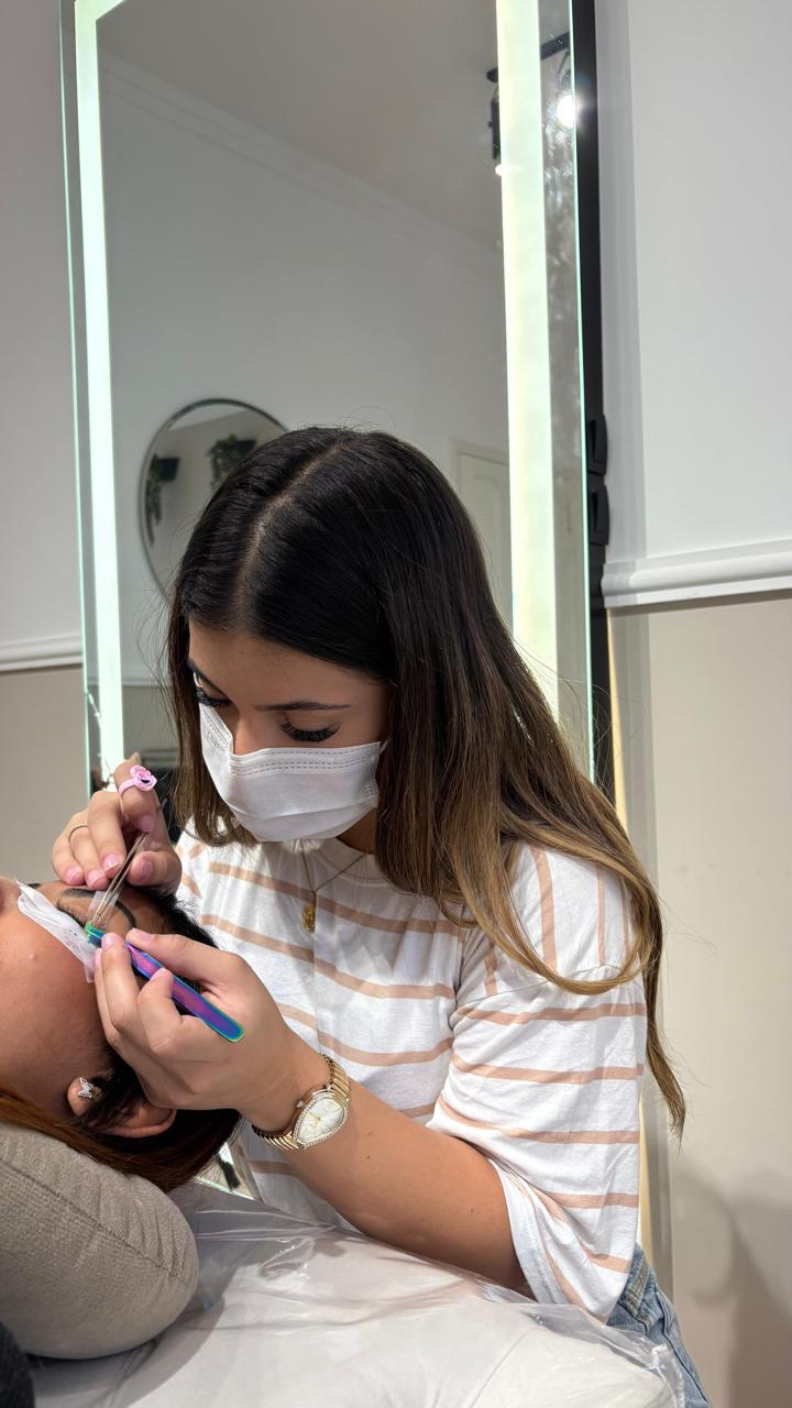 Giovana Lima realizando aplicação de extensão de cílios em uma cliente